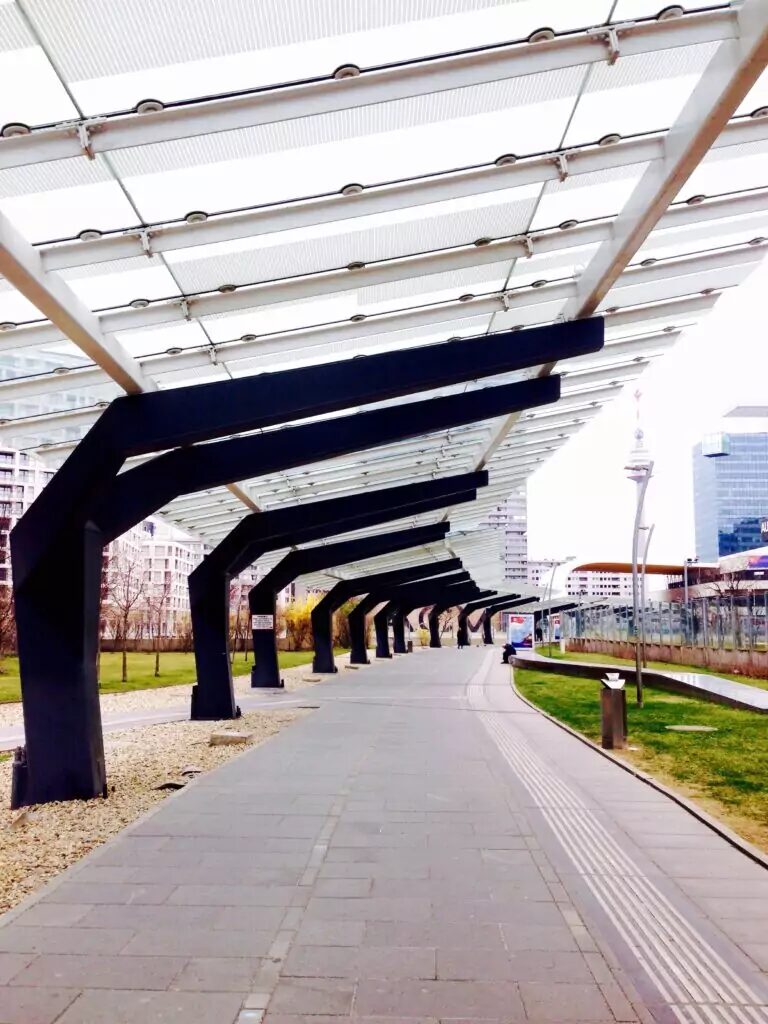 Glass roof overhanging the sidewalk transit stop