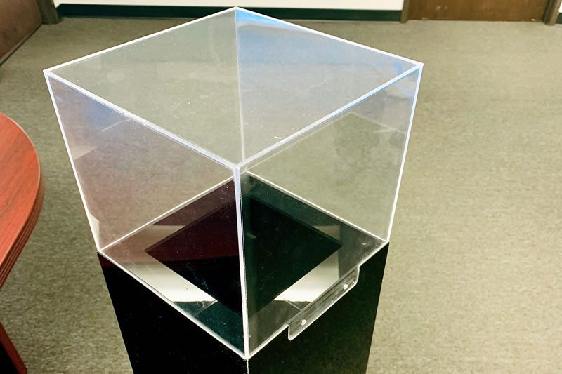 Acrylic cube on black stand