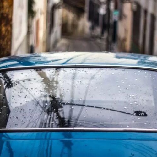 Car with water on its back windshield going through an automatic car wash