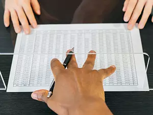 Person with pen in hand pushing a paper to another person.